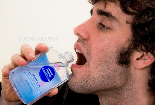 man drinking hand sanitizer