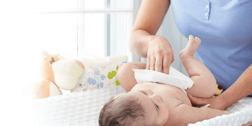 mother cleaning a baby with baby wet wipes